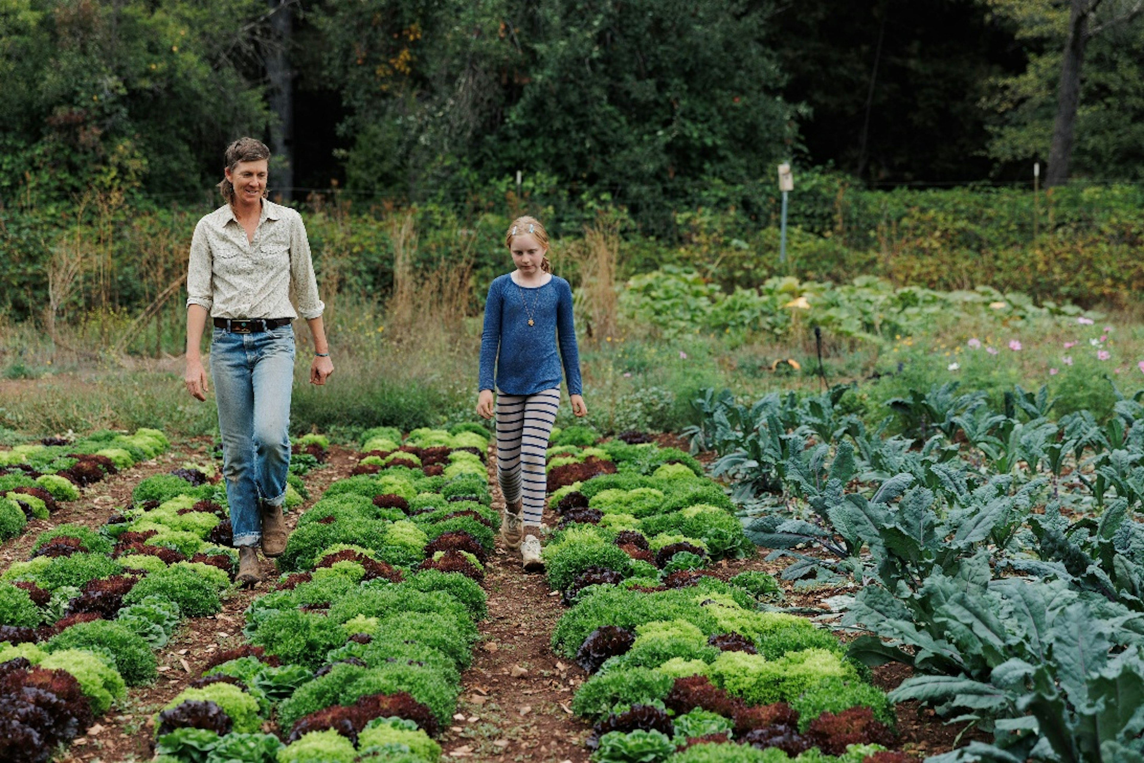 Diane and Sage walking down a path at the farm
