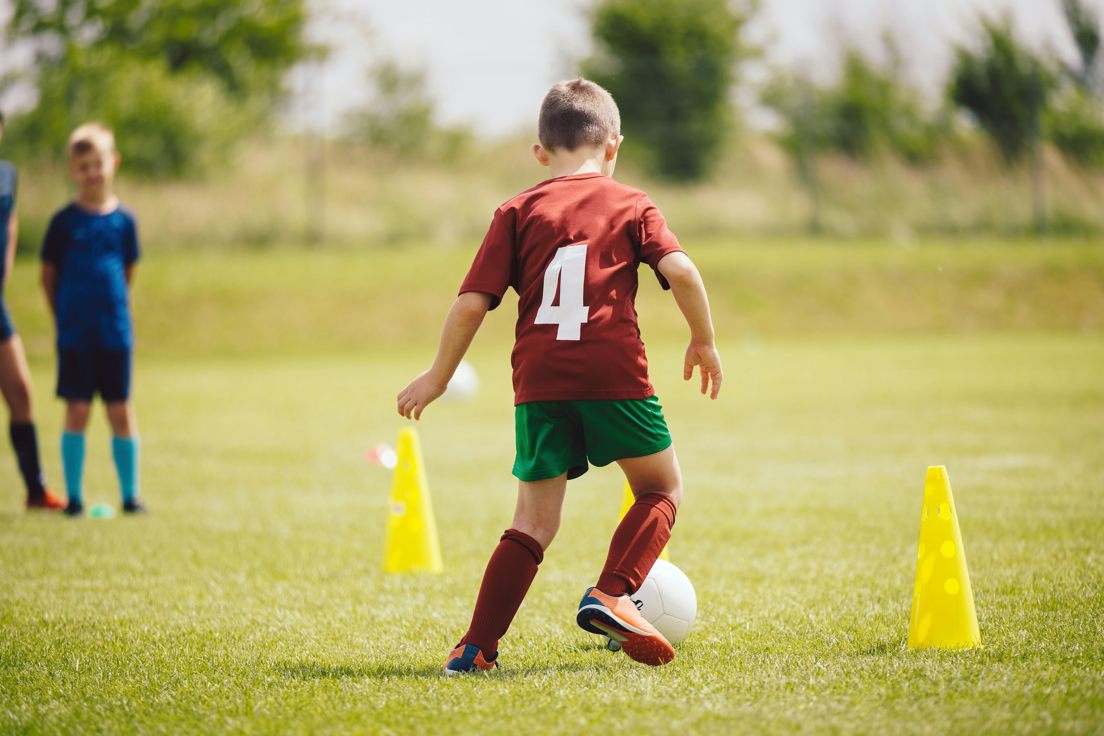 Children practicing soccer on a grass field — lawn regularly used for recreation.